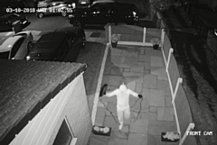 One of the thieves approach the house with an amplifier