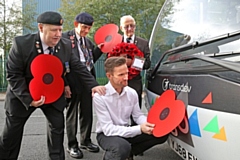 Buses are being adorned with poppies to support the annual Poppy Appeal, as the nation prepares to remember the fallen. From left, veterans Geoff Lister, Michael Scott and Keith Webster watch as engineer Jonathan Ruston fits a poppy to a Transdev bus