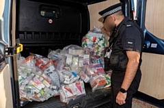 Officers with confiscated items during a previous raid 