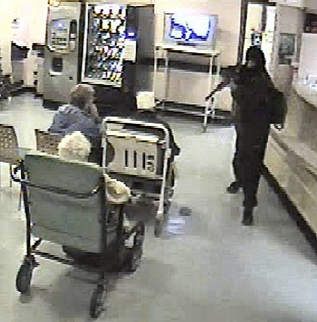 CCTV still shows Charlton pointing the gun at an elderly woman in a wheelchair.