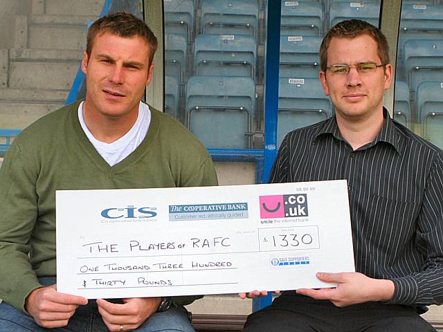 Rochdale Assistant Manager David Flitcroft receives the cheque from a Dale Trust representative