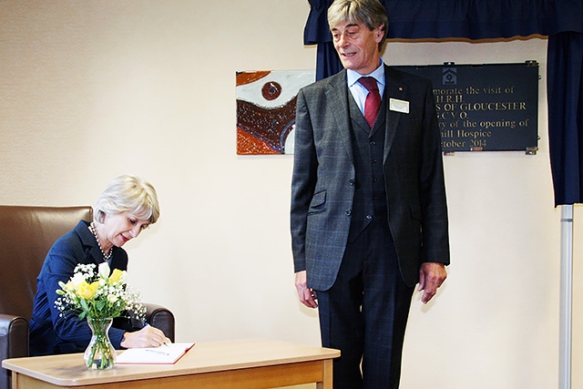 Robert Clegg watches as The Duchess of Gloucester signs the visitors book at Springhill Hospice