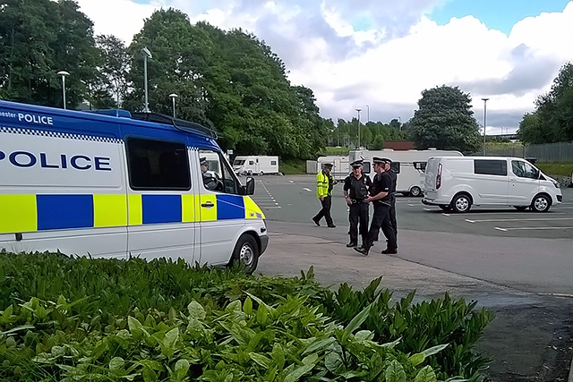 Police supervise the departure of travellers from Tesco car park