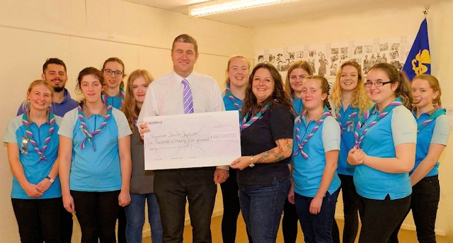 Councillor Chris Furlong presents the final cheque to Heywood Guides Senior Section from his charity runs earlier this year
