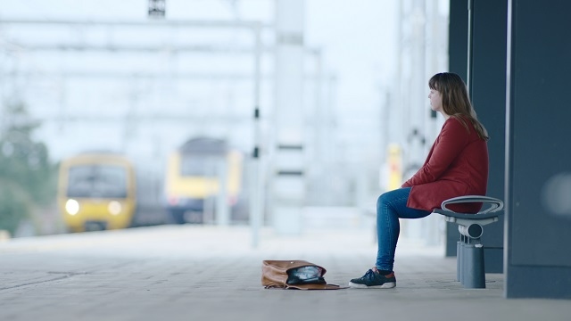 A person sitting alone and isolated on a station platform - Small Talk Saves Lives, says Samaritans