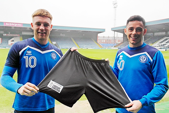 Callum Camps and Ian Henderson show the Prostate Cancer UK logo on Rochdale shorts