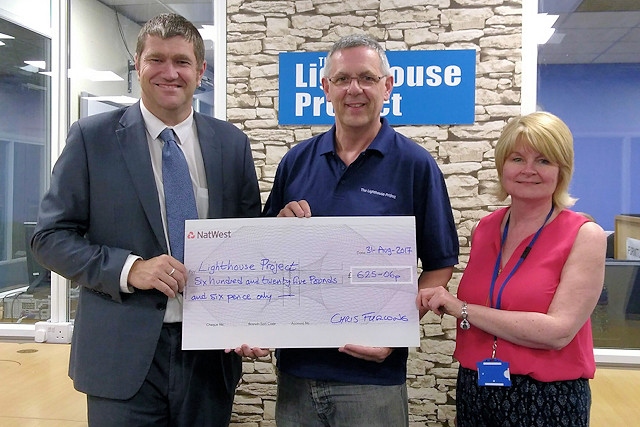 Councillor Chris Furlong presents staff from the Lighthouse Project Middleton with a cheque for £625