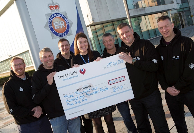 Greater Manchester Police officers present the cheque to The Christie
