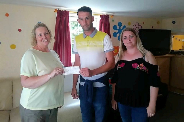 Wesley (centre) presents the cheque to the Children's Moorlands Home