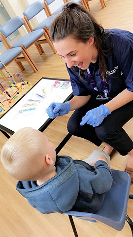 A little boy with a member of the Pennine Care NHS Foundation Trust dental team