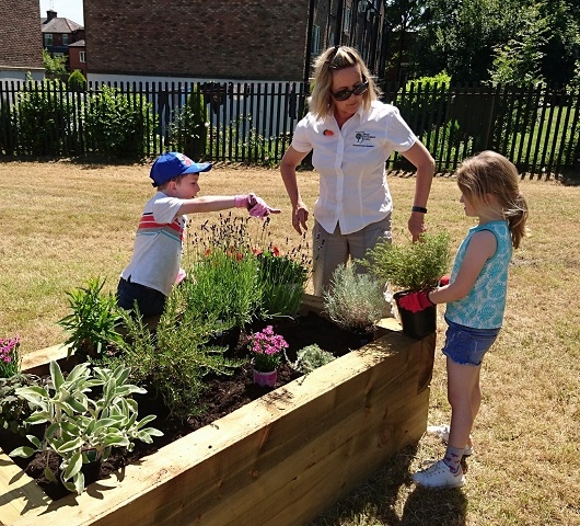 RHS specialist Anne Gunning and child volunteers helping to plant
