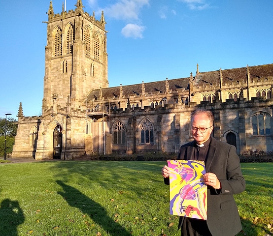 Reverend Mark Coleman outside St Chad's with a poster for Extinction Rebellion