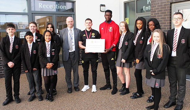 Axel Tuanzebe with staff and students from St Cuthbert's RC High School