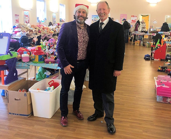 Martyn Allen and Frank Coates surrounded by hundreds of Christmas gifts, donated for struggling parents at Kavanagh & Coates Funeral Services in Heywood