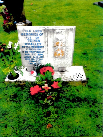 Fusilier Whalley's civilian headstone, which is having flowers lain by a mysterious person