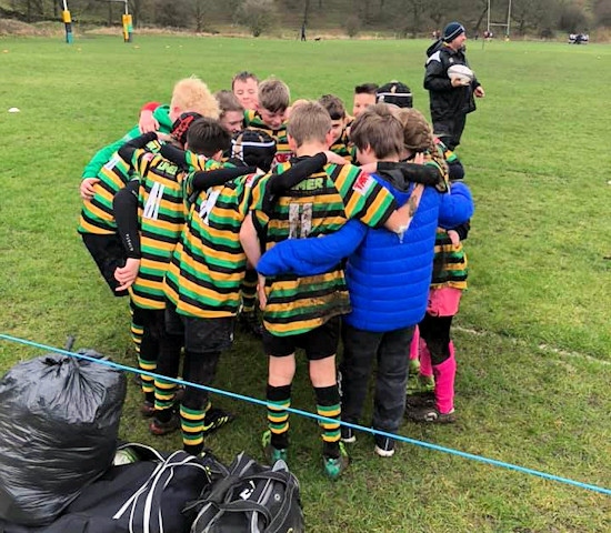 Littleborough's U11s huddle including team mate Daniel Roberts (in the blue coat) before their match with Old Rishworthians