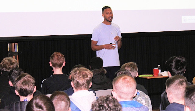 Former student and professional footballer Joe Thompson talks to St Cuthbert's RC High School students