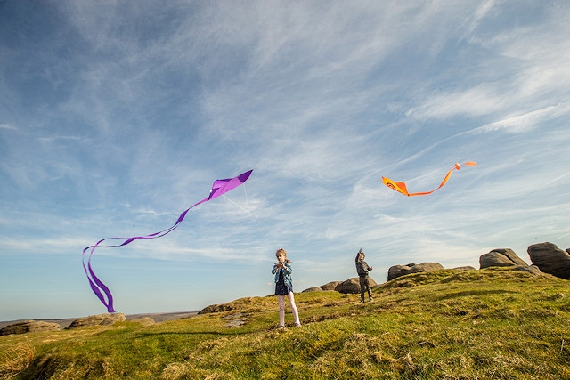 Children fly kites on a sunny day in the South Pennines