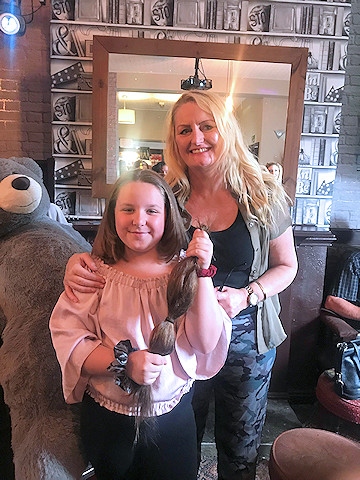 Grace Nock holds her hair donation to The Little Princess Trust
