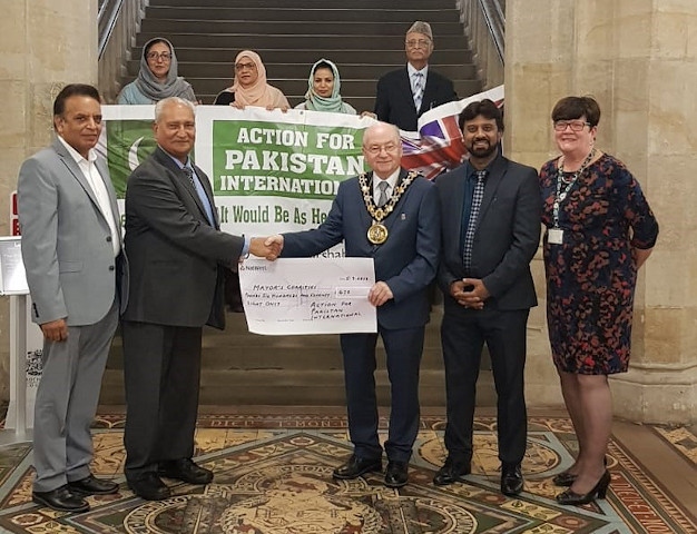 Ghulam Rasul Shahzad OBE, Chairman of Action for Pakistan International, presents Mayor Billy Sheerin with one of the two cheques