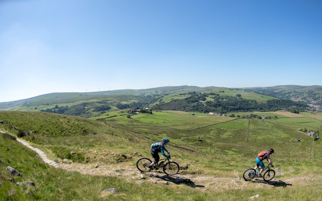 Heather Walker and Liam Spencer riding along the Pennine Bridleway, part of Cycling UK's off-road LEJOG route, at Walsden Moor near Todmorden