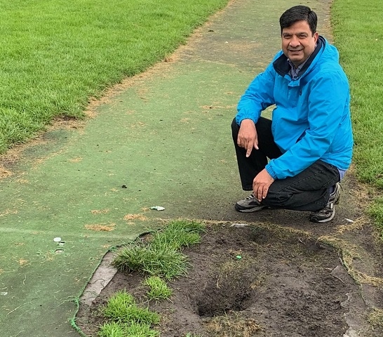 Councillor Faisal Rana inspects the damaged cricket pitch at Lenny Barn