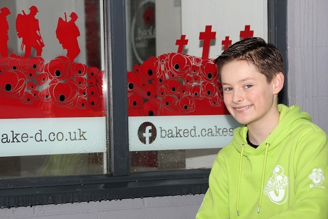 Charlie Hastewell with the poppy window he created at Bacup’s Baked Cakes