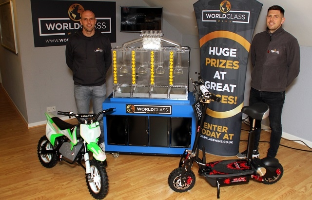 From left, best friends Grant Proctor and Jan Wormald with the lottery machine and some of the prizes that will be won through World Class Wins