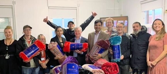 Councillor Rana and Iram Faisal, along with local MP Tony Lloyd, hand the donated blankets to Petrus service manager Edmund Clout, staff and service users