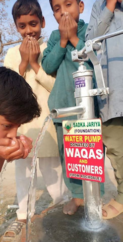 Children with a water pump in Pakistan, provided by Waqas and his customers