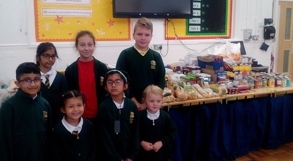 Children from Brimrod Primary School in front of the school's Harvest donations