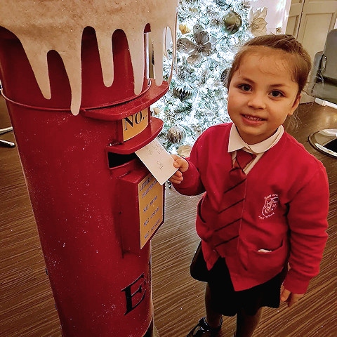 Cora, daughter of Studio 82 salon owner Darcy Jones, posting the first letter in the postbox