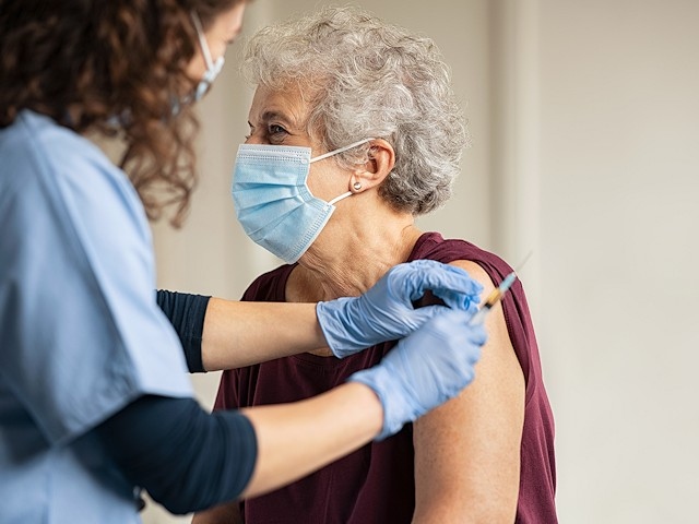 A volunteer administers a Covid vaccine