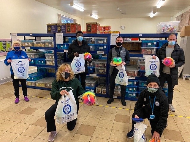 Community Trust Manager Siobhan McElhinney, Rochdale AFC players Kwadwo Baah, Jimmy Ryan and Matty Done (back row) along with kitman Jack Northover (front right) delivered care packs to the Community Warehouse at Sparth Community Centre 