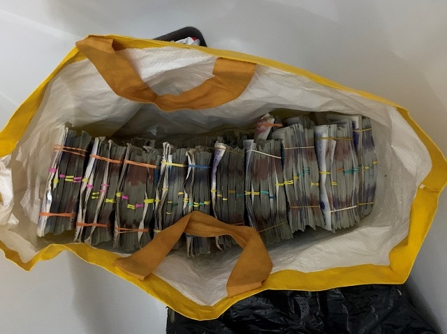 A significant amount of cash had been stashed in bags and thrown onto the roof from the bathroom window in a last-ditch attempt to hide it from officers