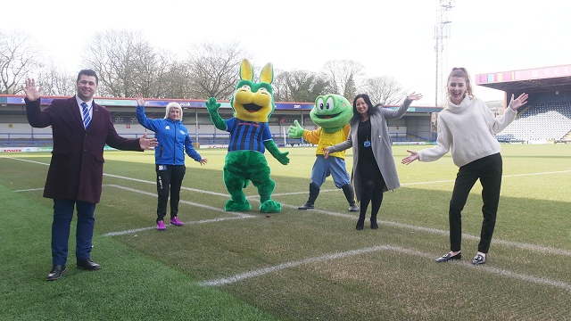 Desmond and Springy at the Crown Oil Arena with staff from Rochdale AFC Community Trust, Rochdale AFC and Springhill Hospice