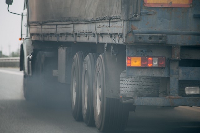 Air pollution from truck vehicle exhaust pipe on road