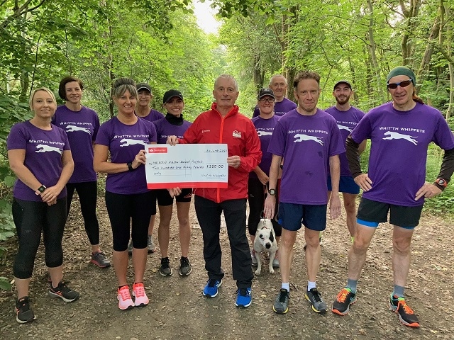 Members of the Whit’th Whippets running group present the £250 cheque to Andy O’Sullivan