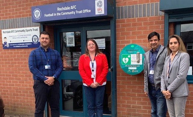 Ryan Bradley, of Rochdale AFC's Community Trust along with local councillors Rachel Massey, Faisal Rana and Iram Faisal at the unveiling of a new defibrillator at Crown Oil Arena