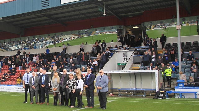 The board of directors join David Kilpatrick's family on the pitch at the match against Oldham Athletic