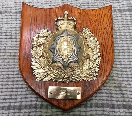 The Household Cavalry helmet insignia mounted on a commemorative plaque
