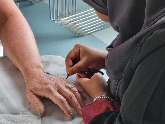 Henna being applied to a woman's hand