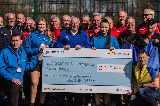 Players from the Walking Fotoball League and team members Your Trust Rochdale present the cheque to Michael Krylszyn, committee member of the Association of Ukrainians of Great Britain (Rochdale branch)
