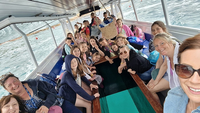 Alumnos y personal en un viaje en barco con fondo de cristal