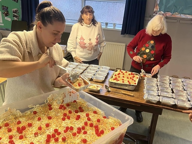 Volunteers dish up trifle for the Christmas party at Thrum Hall
