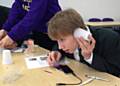 Wardle Academy student building his own set of headphones using a magnet, copper wire, paper cup and an audio socket