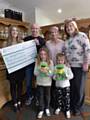 Peter Griffiths and family present a cheque to Springhill Hospice's Sarah Ford