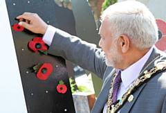Mayor Mohammed Zaman places a poppy on the Memorial Pop-up Garden