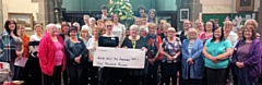 Milnrow and District WI present the cheque to Freda, a volunteer with the North West Air Ambulance