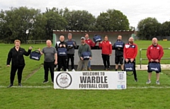 Bev Wrigley from Engaging Safety (far left) presents the first aid kits to Wardle JFC